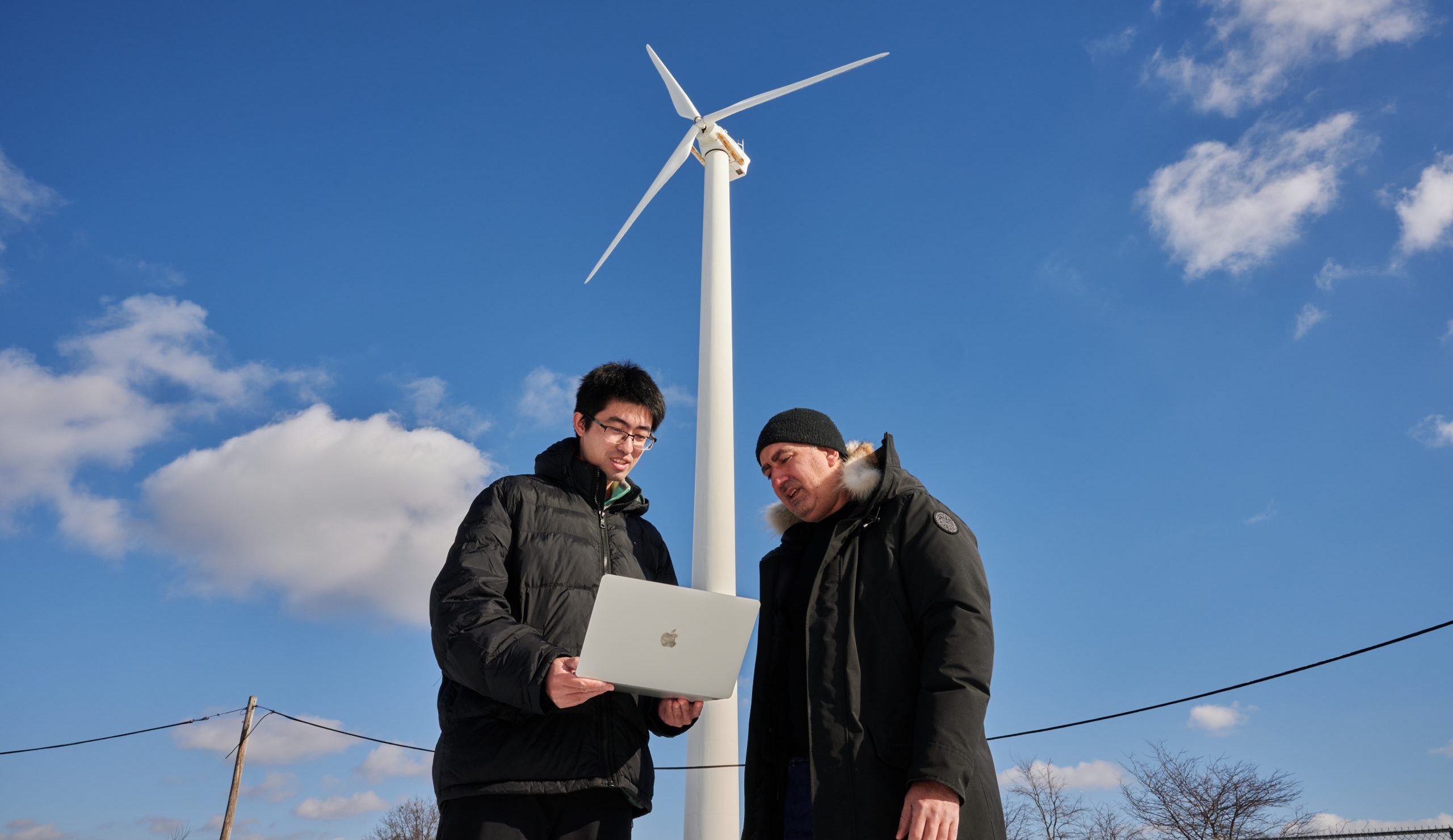 Georgios Matheou, assistant professor of mechanical engineering, and Yonggie Lu, a graduate student, visit a windmill in New Haven on Jan. 17, 2024. (Peter Morenus/UConn Photo)