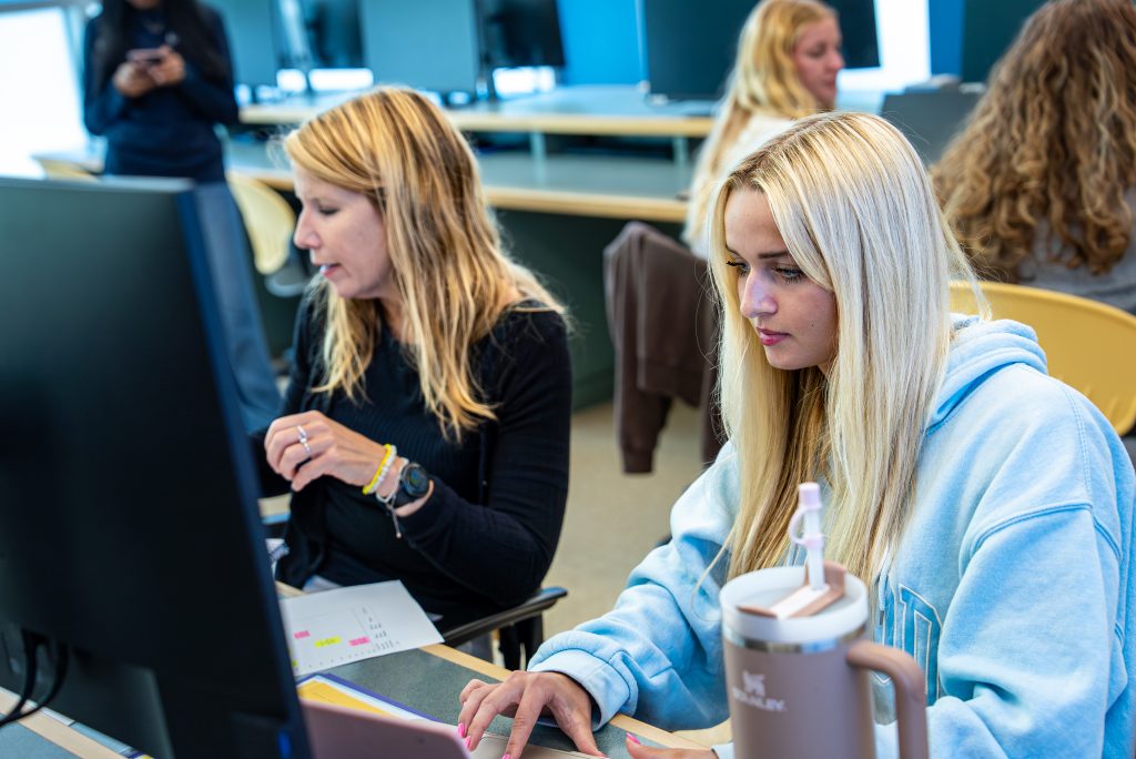 two female Undergraduate students in front of computer monitors