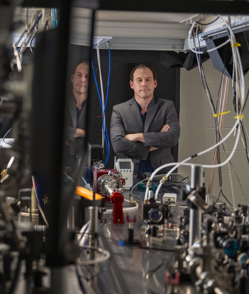 Portrait of professor standing in front of laser table