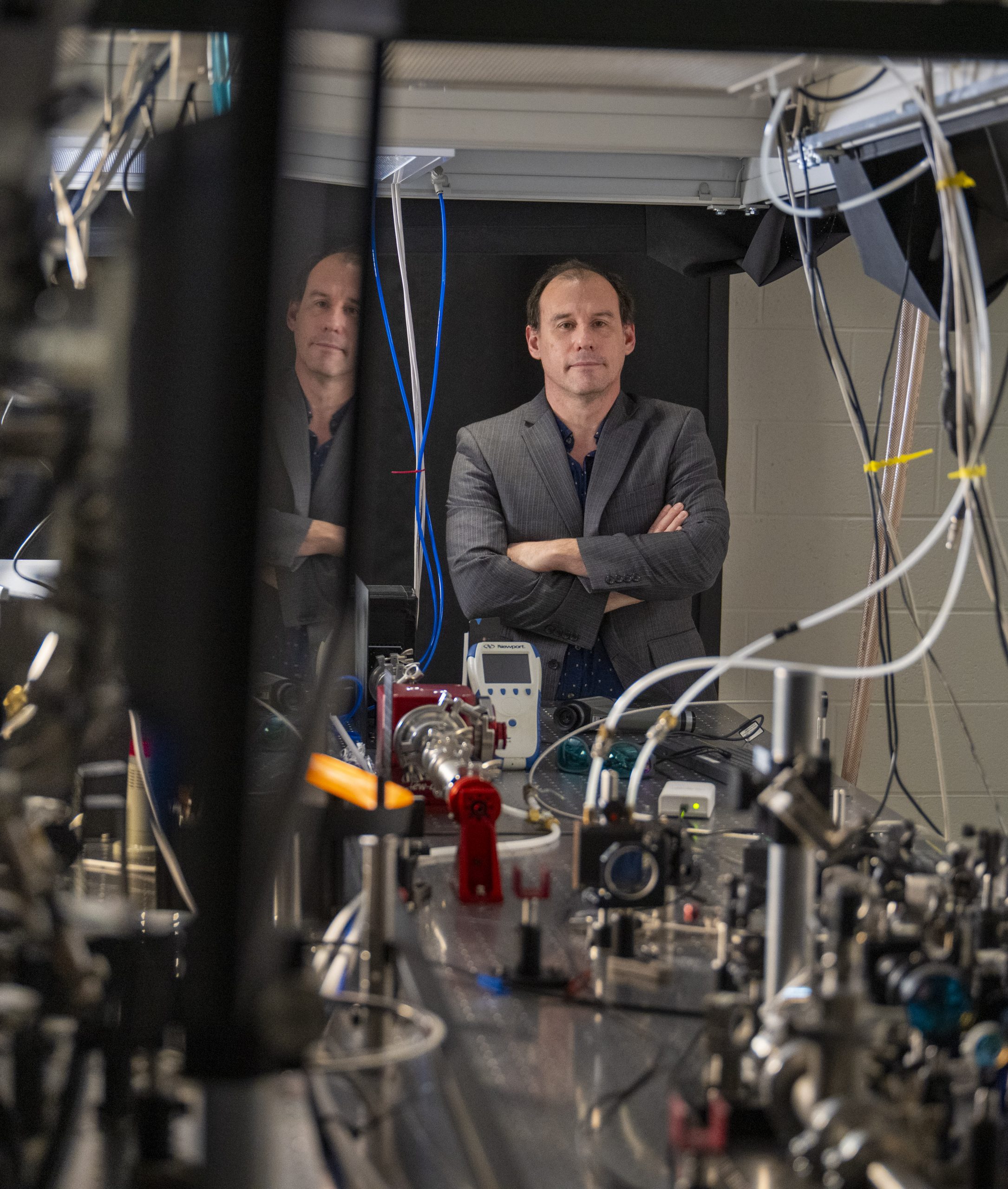 Portrait of professor standing in front of laser table
